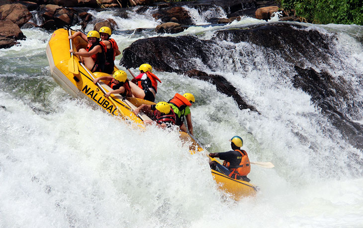 Tourists in a yellow raft go down rapids on river nile