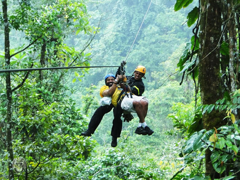 A man Ziplining with a Guide over the Mabira forest Canopy