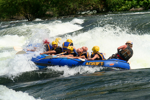 Tourists in Uganda White water rafting on river Nile in a blue raft