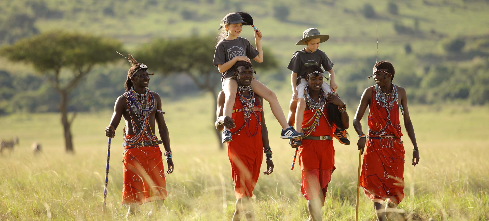 3 Masai Men carrying to tourists in the Masai Mara